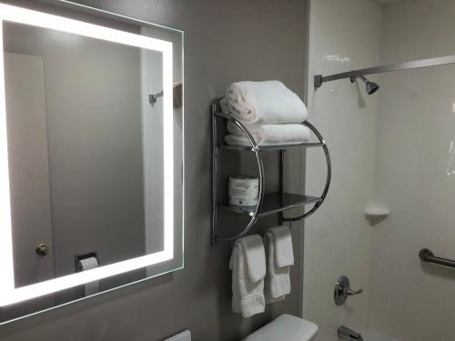 a bathroom with a mirror and a sink with towels at DuPont Suites - Louisville - St. Matthews in Louisville