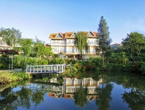 a large building with a bridge over a body of water at Dalat Terrasse Des Roses Villa in Da Lat