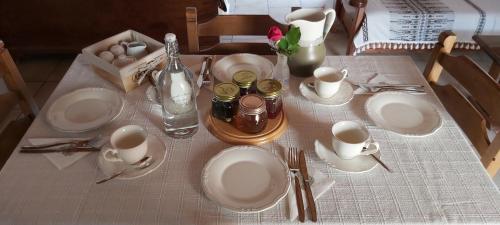 a table with white plates and silverware on a table at Traditional house in Asfendiou in Kos Town