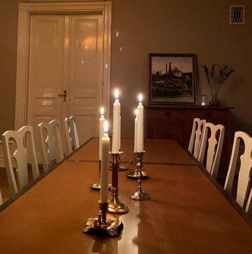 a dining room table with three candles on it at Bergsgården Hotell & Konferens in Bergsgården