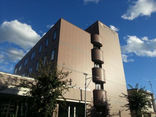 un gran edificio con un edificio con un poste delante en Hotel Sunfuraton, en Furano