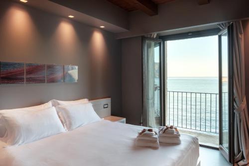 1 dormitorio con cama grande y ventana grande en Il Casato Deluxe Rooms en Scilla