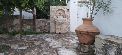 a large vase sitting on the side of a building at Traditional house in Asfendiou in Kos Town