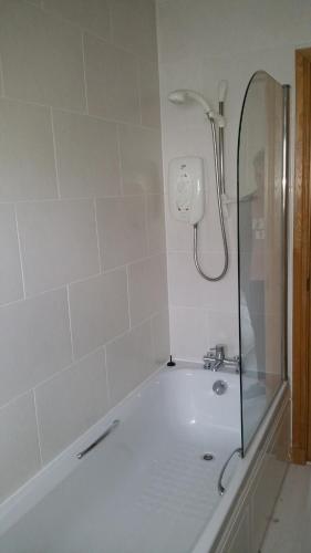 a bath tub with a shower in a bathroom at The Cobblers in Inverness