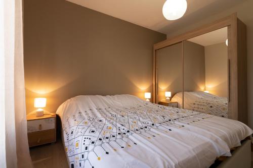 sypialnia z dużym łóżkiem z lustrem w obiekcie Le Borie climatisé w mieście Arles