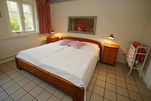 Un dormitorio con una cama grande y una ventana en Döns, en Utersum