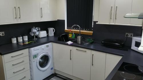 uma cozinha com uma máquina de lavar roupa no balcão em The Cobblers em Inverness
