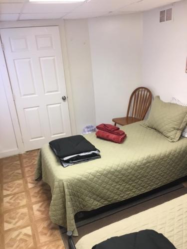 a room with a bed with a chair and a door at Art Gallery Hostel in Whitefield