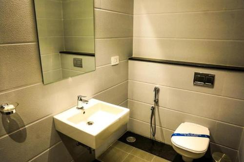 马伊拉杜图赖Laya Regency的带水槽、马桶和镜子的浴室