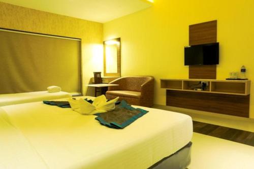 a hotel room with a bed and a chair at Laya Regency in Mayiladuthurai