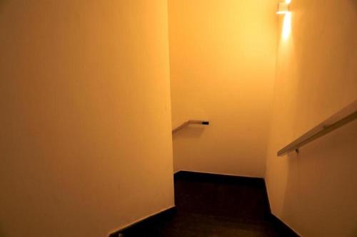 a hallway with a white wall and a light at Laya Regency in Mayiladuthurai