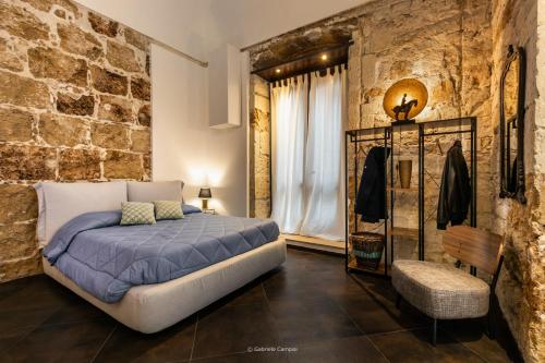 - une chambre avec un lit et un mur en briques dans l'établissement GARIBALDI MAISON DE CHARME, à Avola
