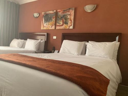 a hotel room with two beds with white pillows at Royal Hotel in Polokwane