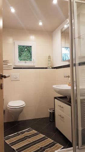 een badkamer met een wit toilet en een wastafel bij Ferienhaus am Mühlenweg in Winsen