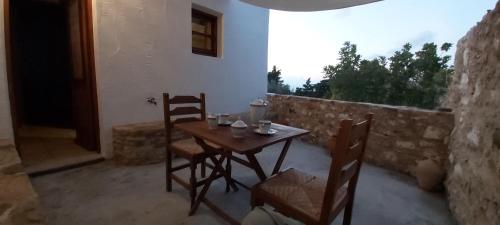 a wooden table and chairs in a room with a window at Traditional house in Asfendiou in Kos Town