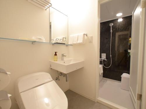 a bathroom with a white toilet and a sink at Hotel Oriental Express Tokyo Kamata in Tokyo
