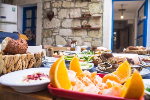 a table topped with plates of food with oranges and other foods at Lavinia Otel in Cesme
