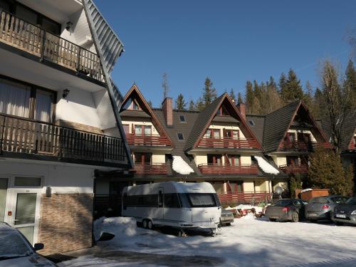 a van parked in a parking lot in front of a house at Kamping u Łukasza in Zakopane