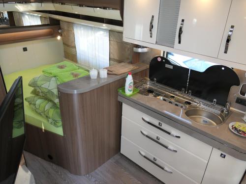 a small kitchen with a sink and a bed at Kamping u Łukasza in Zakopane