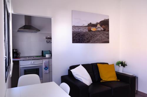 a living room with a black couch with yellow pillows at V.V. Casa Quintero in Tigaday