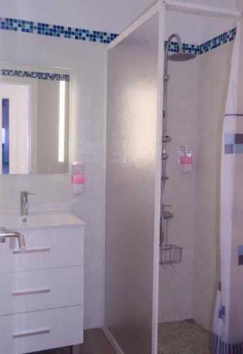 a white bathroom with a shower and a sink at V.V. Casa Quintero in Tigaday