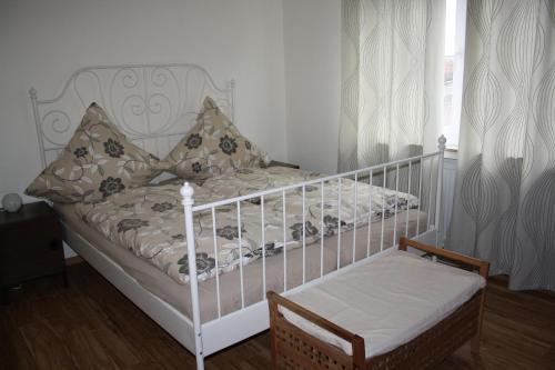 オルスベルクにあるFerienwohnung Panorama IIの寝室に枕と椅子が置かれた白いベビーベッド
