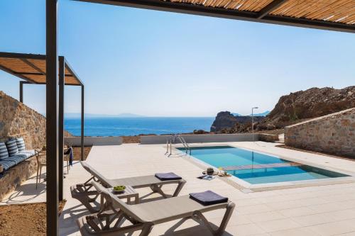 a villa with a pool and a view of the ocean at Varkotopi Villas in Agios Pavlos