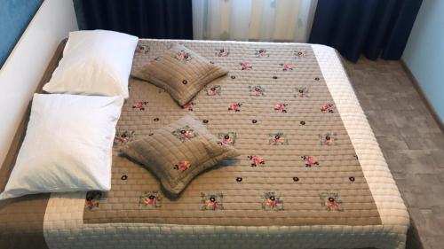 a bed with four pillows on top of it at Laguna Albastră Residence in Piatra Neamţ