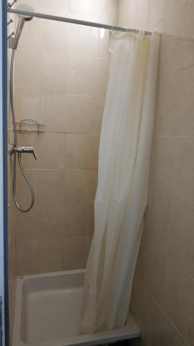 a shower with a white shower curtain in a bathroom at Cool Traveler in Kyiv