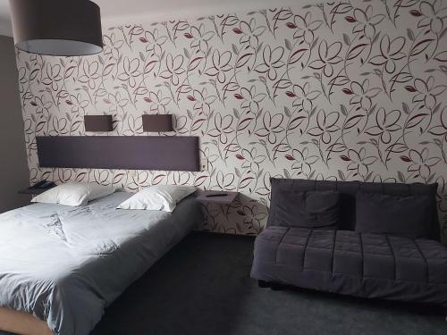Hotel Des Roches في Cugnon: غرفة نوم بسرير وجدار بورق جدران