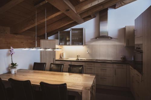 a kitchen with a wooden table and some chairs at Haus Mischabel in Zermatt