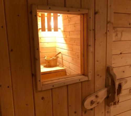 uma pequena sauna com uma janela numa parede de madeira em Feielhof em Krakaudorf
