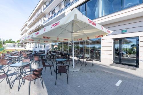 a group of tables and chairs sitting outside of a building at Blue Marine Mielno in Mielno