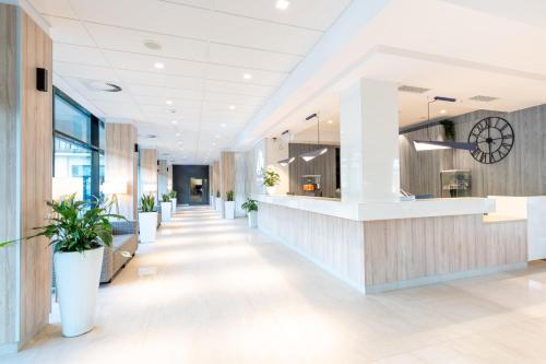 an office lobby with a reception counter and potted plants at Blue Marine Mielno in Mielno