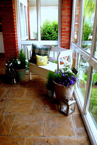 a porch with a bench and some potted plants at Beachlands Hotel in Weston-super-Mare