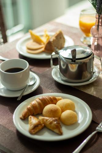 a table with two plates of food and a cup of coffee at Hotel Coral Beach in Tamandaré