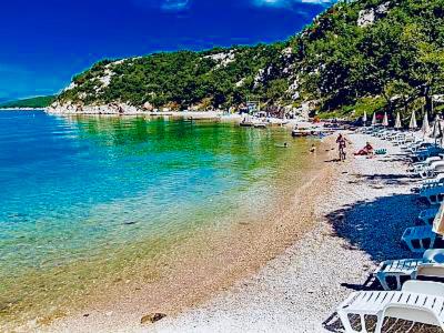 a beach with chairs and people in the water at Lux dodo in Dramalj