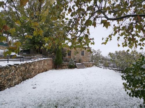 a yard covered in snow in front of a house at Casa Rural la Insula in Santa María de la Alameda