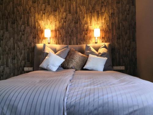 a bedroom with a large bed with pillows at Villa Kopp-Das Gästehaus in Höpfingen