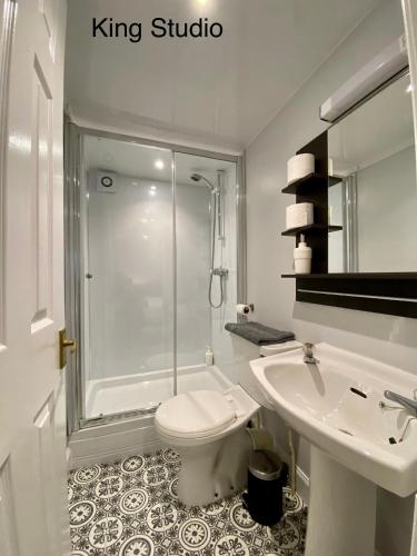 a bathroom with a shower and a toilet and a sink at Studio Apartments on the Square in Kelso