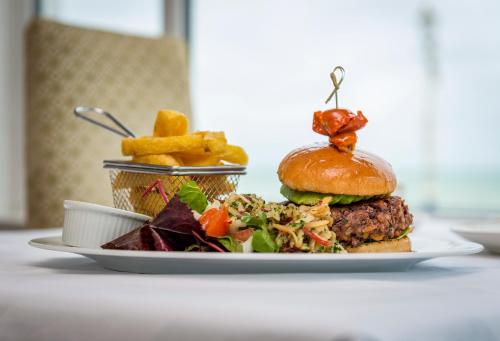 a plate of food with a burger and french fries at Langham Hotel Eastbourne in Eastbourne