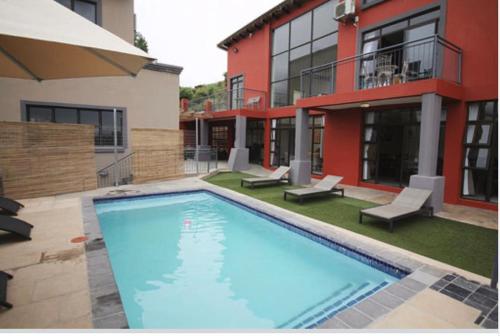 a large swimming pool in front of a building at Scenery Guest House in Kokstad