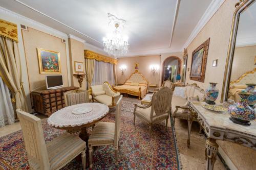 uma sala de estar com um sofá, uma mesa e cadeiras em Stanze Barocche em Modica