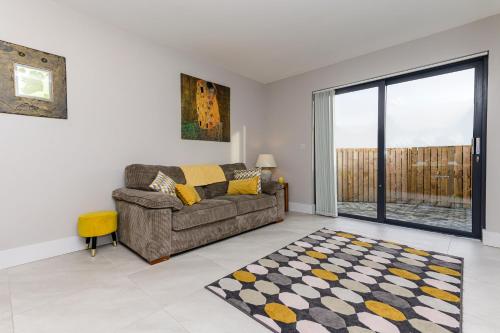 a living room with a couch and a large window at Park View - 4 Star Luxury in Belfast