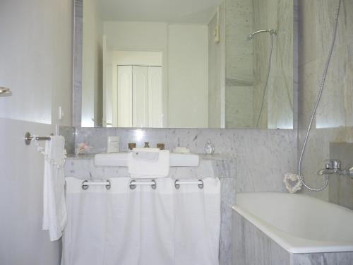 biała łazienka z umywalką, wanną i prysznicem w obiekcie Antibes Seaside one room studio in Salis Beach w mieście Antibes