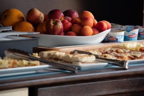een buffet met een kom appels en sinaasappels bij Hotel Baia Di Venere in San Vito lo Capo