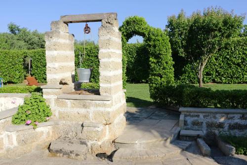 a stone wall with an arch in a garden at L'Antico Casale Fulaciano in Galatone