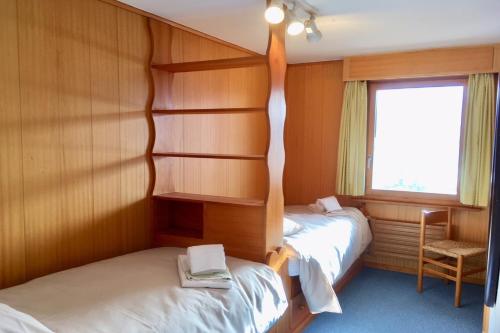 two beds in a small room with a window at Majestic 424 in Bagnes