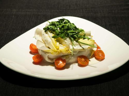 a white plate of food with tomatoes on a table at Ibis Budget Lleida in Lleida