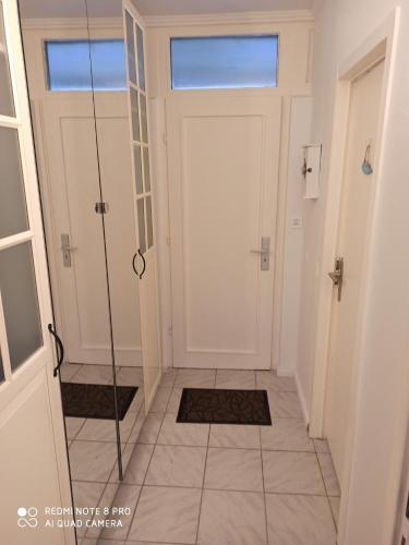 a hallway with a white door and a tile floor at Ferienwohnung Küstenkind in Wendtorf